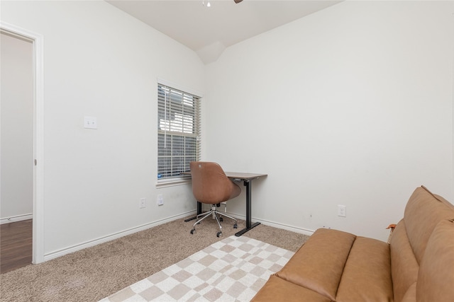 carpeted office featuring lofted ceiling