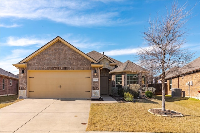 view of front of home with central air condition unit, a front lawn, and a garage