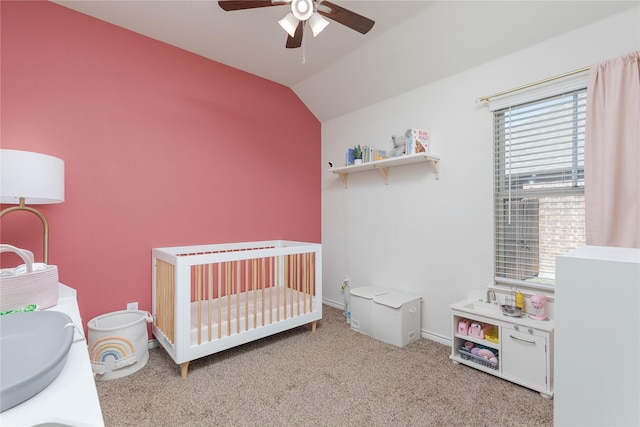 bedroom featuring vaulted ceiling, a nursery area, ceiling fan, light carpet, and sink