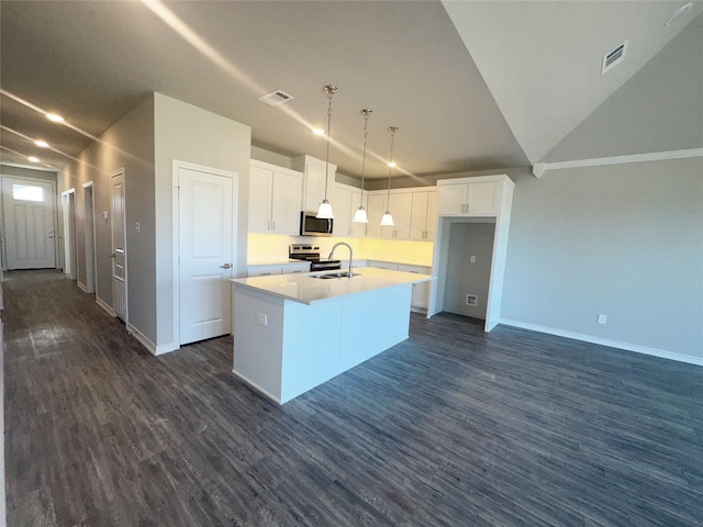 kitchen with pendant lighting, lofted ceiling, dark wood-type flooring, white cabinets, and an island with sink