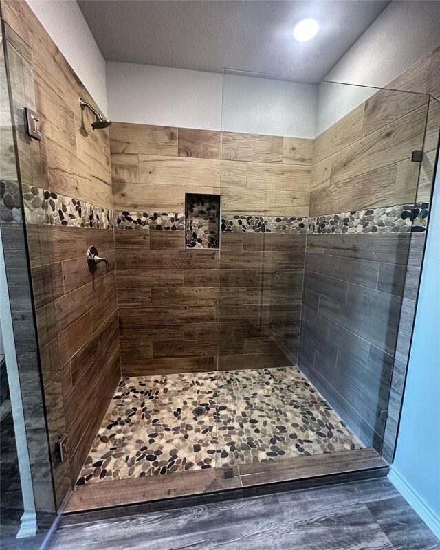 bathroom featuring hardwood / wood-style flooring and walk in shower