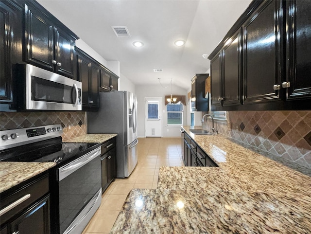 kitchen featuring sink, hanging light fixtures, stainless steel appliances, light stone countertops, and light tile patterned flooring