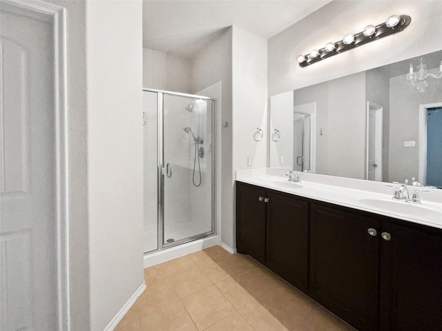 bathroom featuring a shower with door, vanity, and tile patterned floors