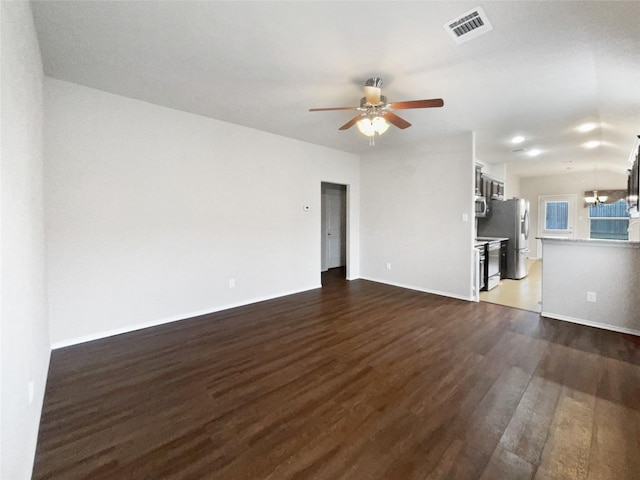 unfurnished living room with dark wood-type flooring and ceiling fan with notable chandelier