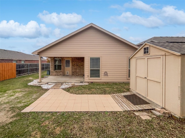 back of property with a patio, a shed, and a lawn