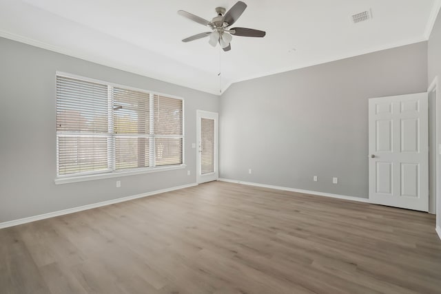 empty room featuring ceiling fan, lofted ceiling, light hardwood / wood-style floors, and ornamental molding