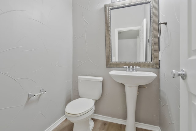 bathroom with hardwood / wood-style floors and toilet