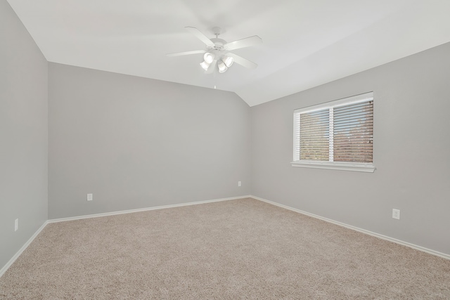 unfurnished room featuring ceiling fan, vaulted ceiling, and carpet