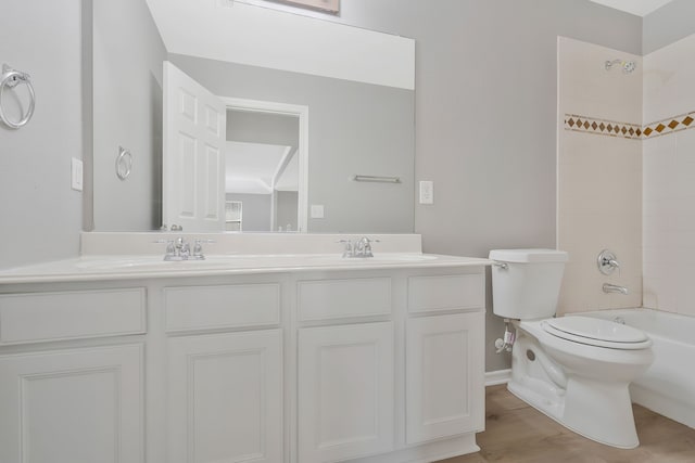 full bathroom featuring tiled shower / bath, wood-type flooring, vanity, and toilet