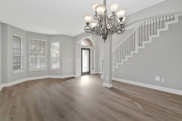 foyer entrance with an inviting chandelier and hardwood / wood-style floors