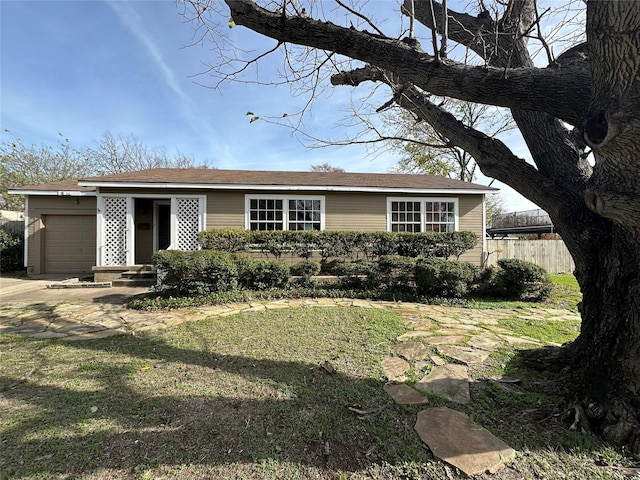 view of front of house featuring a front lawn, fence, and an attached garage