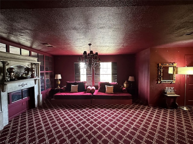 carpeted cinema room with a chandelier, visible vents, a fireplace, and a textured ceiling