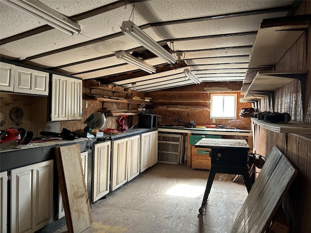 kitchen with dark countertops, cream cabinets, and vaulted ceiling