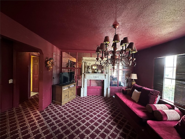 living room featuring dark colored carpet, a textured ceiling, and a chandelier