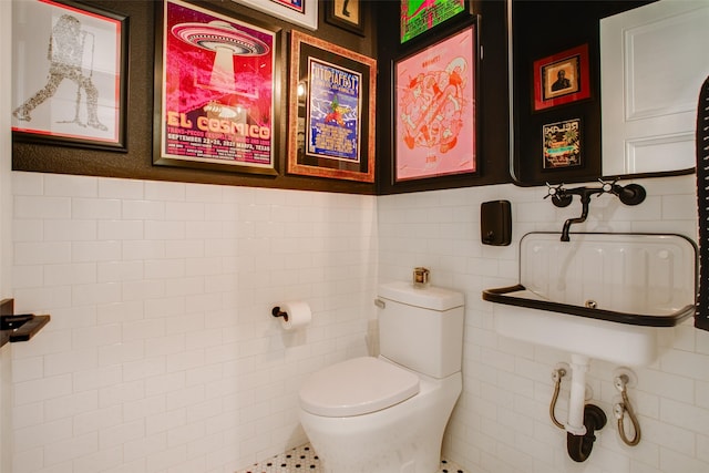 bathroom with toilet and tile walls