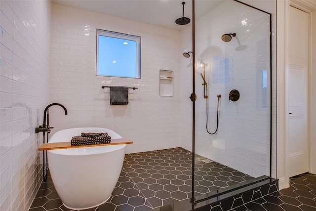 bathroom with tile patterned flooring, separate shower and tub, and tile walls