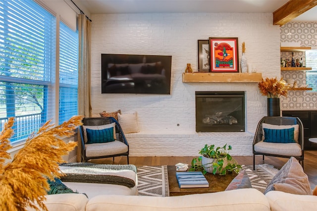 living room with beamed ceiling, wood-type flooring, a wealth of natural light, and brick wall