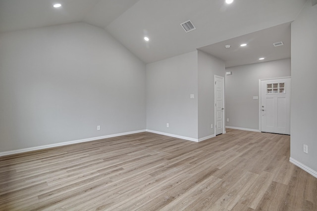 empty room featuring light hardwood / wood-style floors and vaulted ceiling