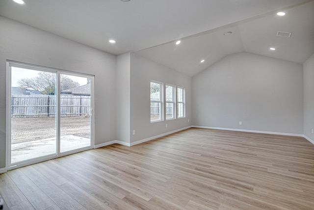 empty room with vaulted ceiling and light hardwood / wood-style flooring