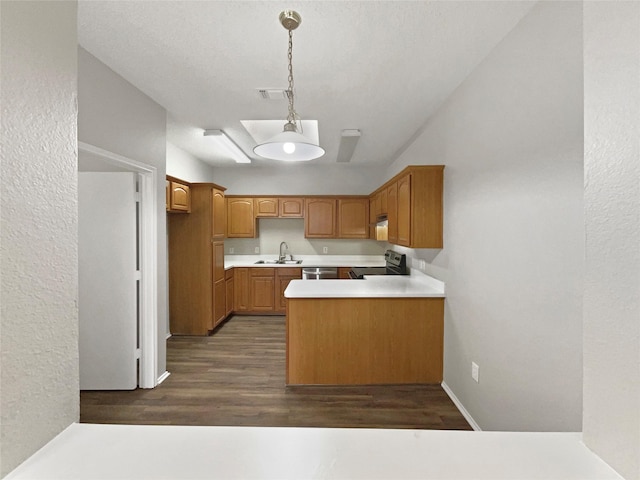 kitchen featuring kitchen peninsula, dark wood-type flooring, sink, electric range, and decorative light fixtures