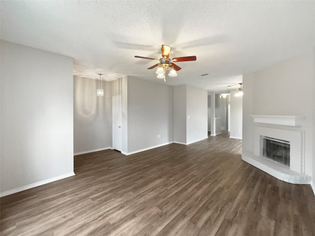 unfurnished living room featuring ceiling fan, dark wood-type flooring, and a textured ceiling