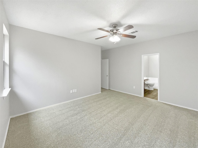 unfurnished bedroom with carpet flooring, ceiling fan, and connected bathroom