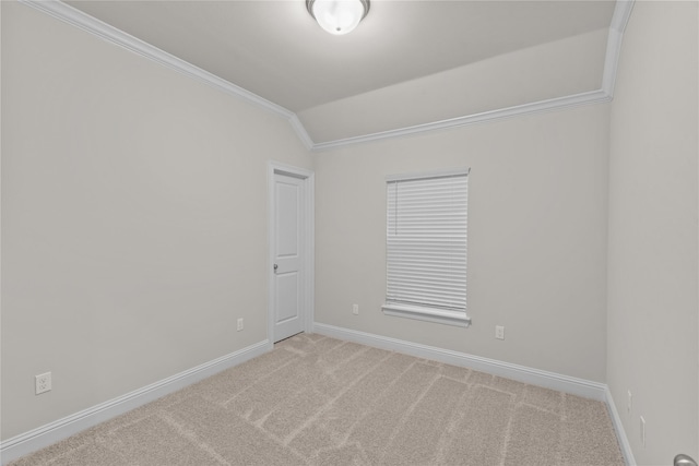 carpeted spare room featuring crown molding and vaulted ceiling