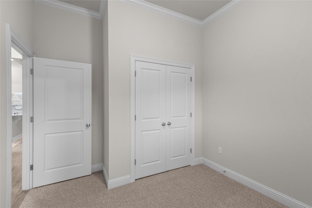 unfurnished bedroom featuring light carpet, a closet, and crown molding