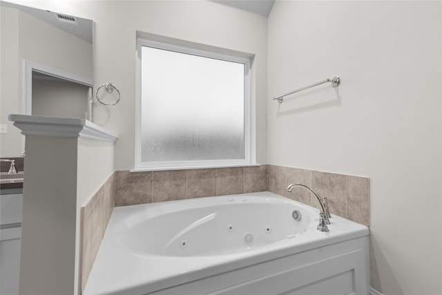 bathroom featuring sink and a tub to relax in