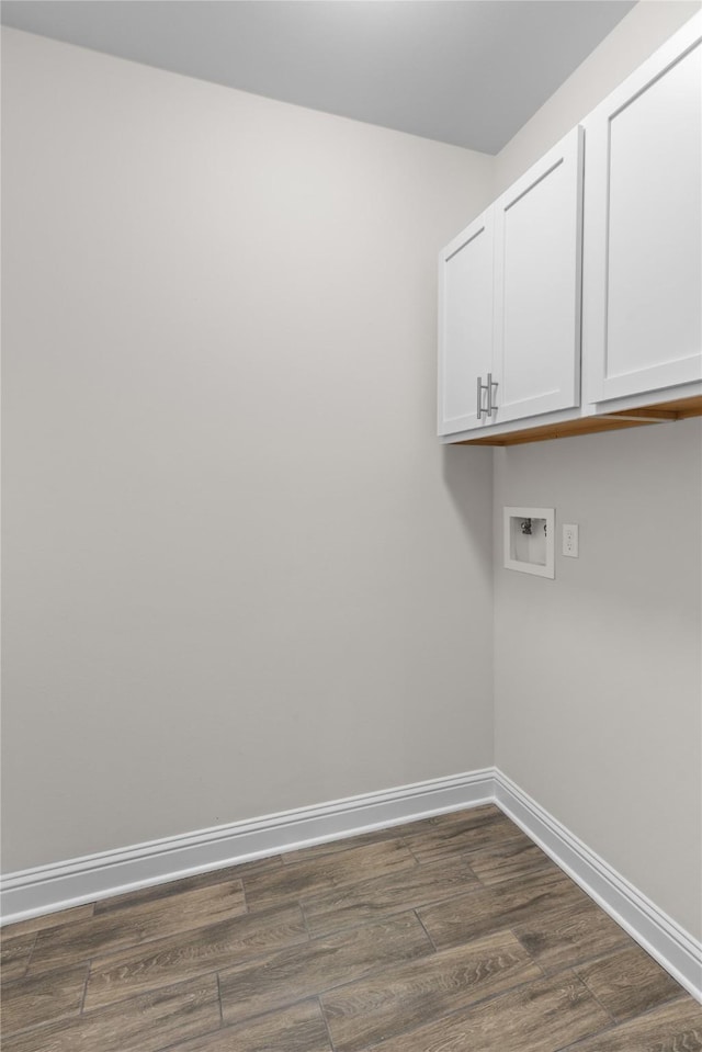 washroom featuring washer hookup, dark hardwood / wood-style floors, and cabinets