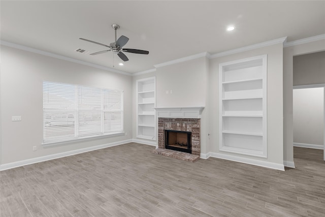 unfurnished living room featuring built in features, light hardwood / wood-style flooring, a fireplace, and ceiling fan