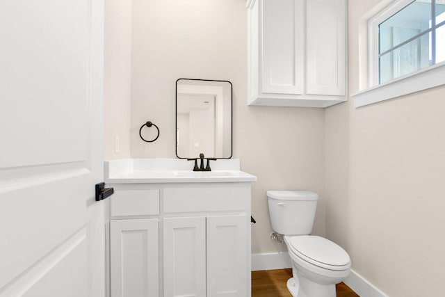 bathroom featuring vanity, wood-type flooring, and toilet