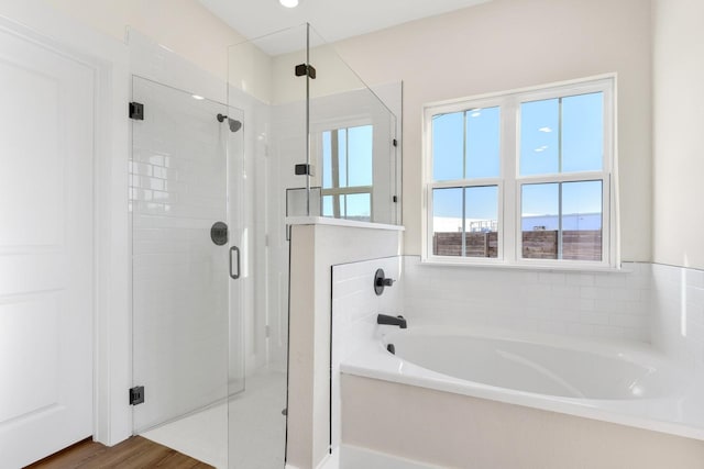 bathroom with shower with separate bathtub and hardwood / wood-style floors