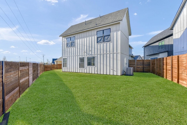 back of property featuring central AC and a lawn