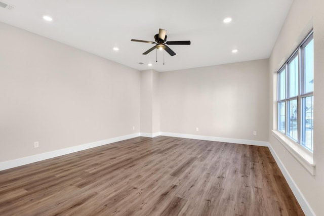 spare room with ceiling fan and light wood-type flooring