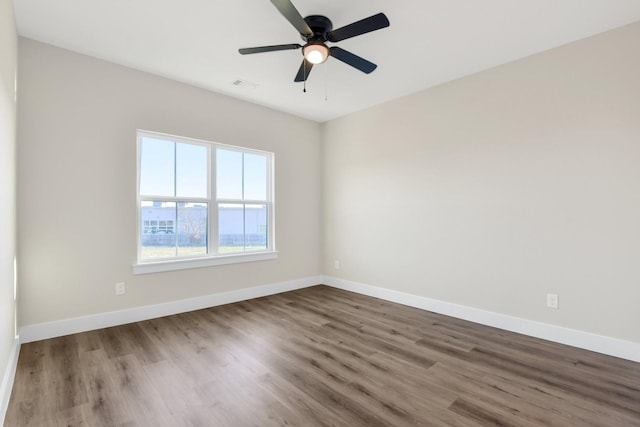 empty room with hardwood / wood-style floors and ceiling fan