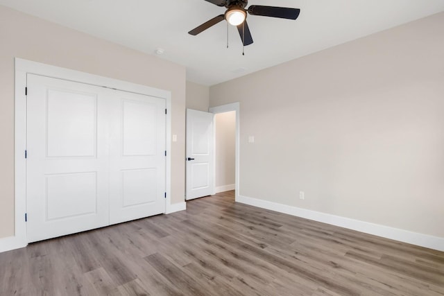 unfurnished bedroom with light hardwood / wood-style floors, a closet, and ceiling fan