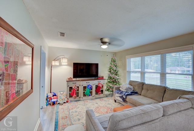 living room featuring ceiling fan and hardwood / wood-style floors