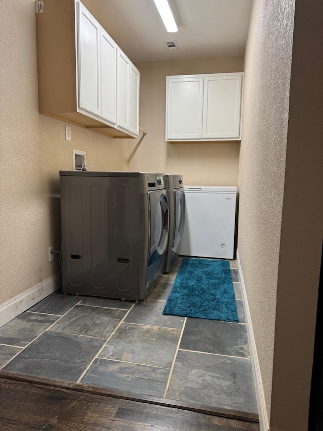 washroom with cabinets and washing machine and dryer