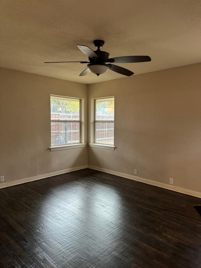 spare room with ceiling fan and dark wood-type flooring