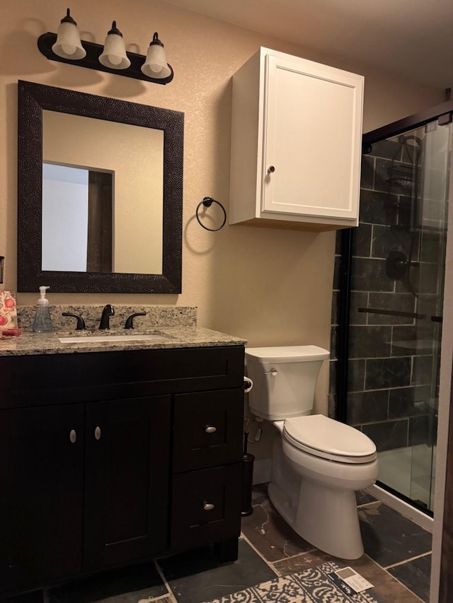 bathroom featuring tile patterned flooring, vanity, toilet, and walk in shower