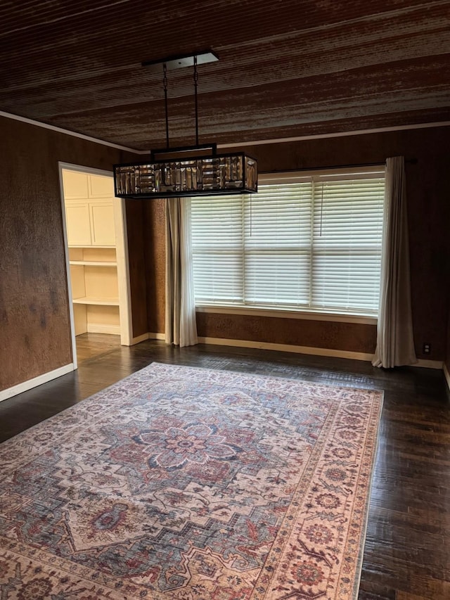 unfurnished dining area with crown molding, dark wood-type flooring, and wood ceiling