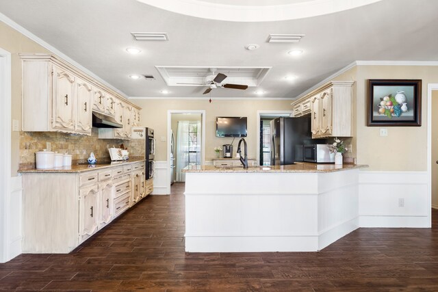 kitchen featuring dark hardwood / wood-style floors, light stone counters, and stainless steel appliances