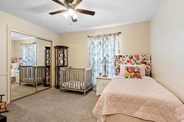 bedroom featuring ceiling fan, light colored carpet, and a closet