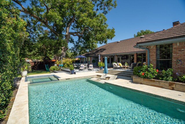 view of pool with an in ground hot tub and a patio