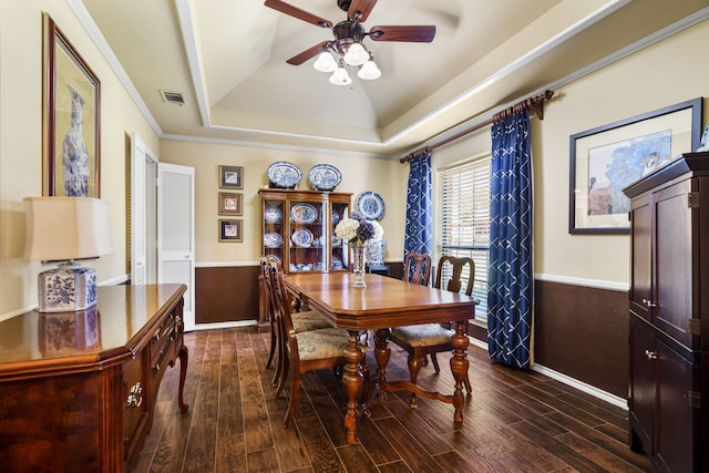 dining space with a tray ceiling, ceiling fan, dark wood-type flooring, and vaulted ceiling