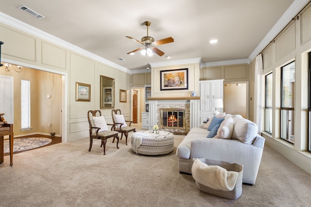 carpeted living room with crown molding and ceiling fan