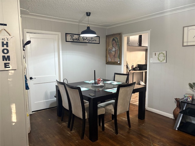 dining space featuring dark hardwood / wood-style flooring, ornamental molding, and a textured ceiling