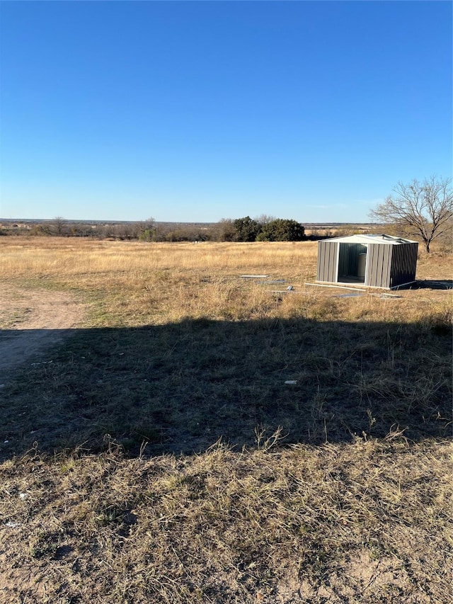 view of yard featuring an outbuilding and a rural view