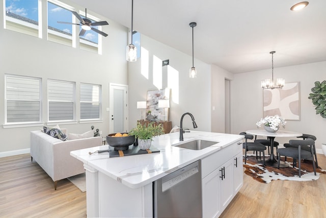 kitchen featuring white cabinetry, sink, stainless steel dishwasher, and light hardwood / wood-style floors